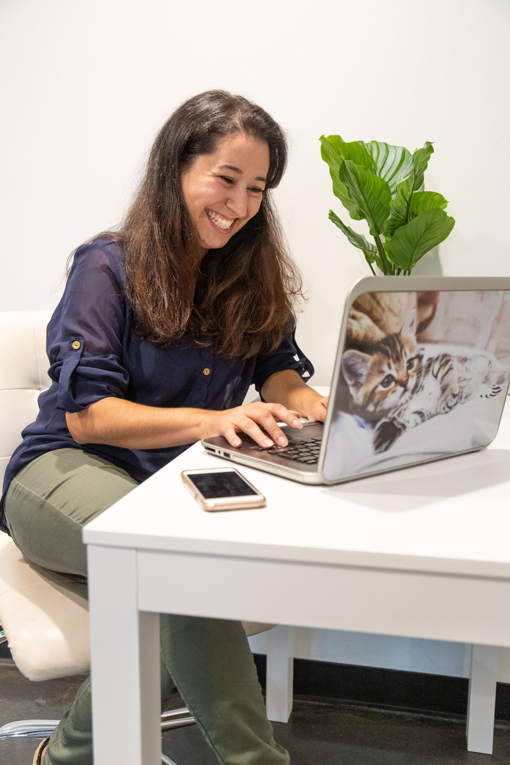 Instagram Coach Naty Montandon at her computer with a white desk and green plant