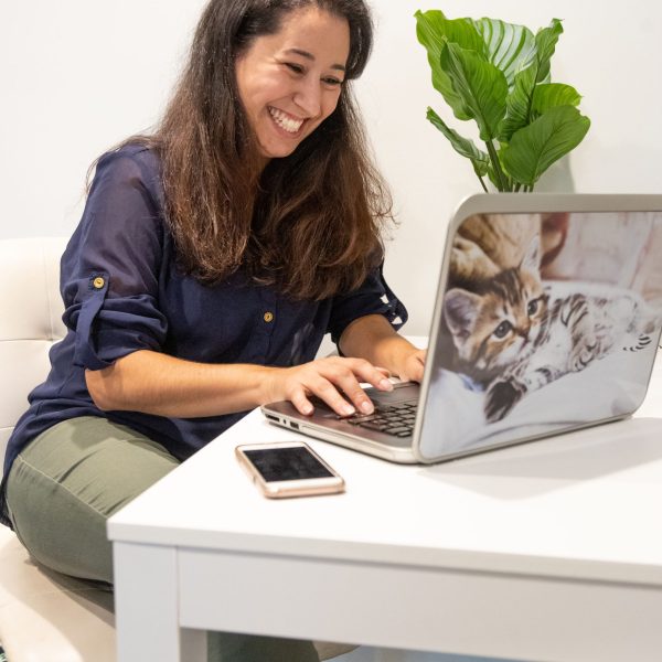 Instagram Coach Naty Montandon at her computer with a white desk and green plant